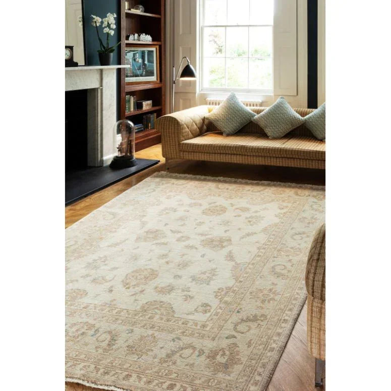 Cream patterned area rug in living room with beige sofa and blue cushions