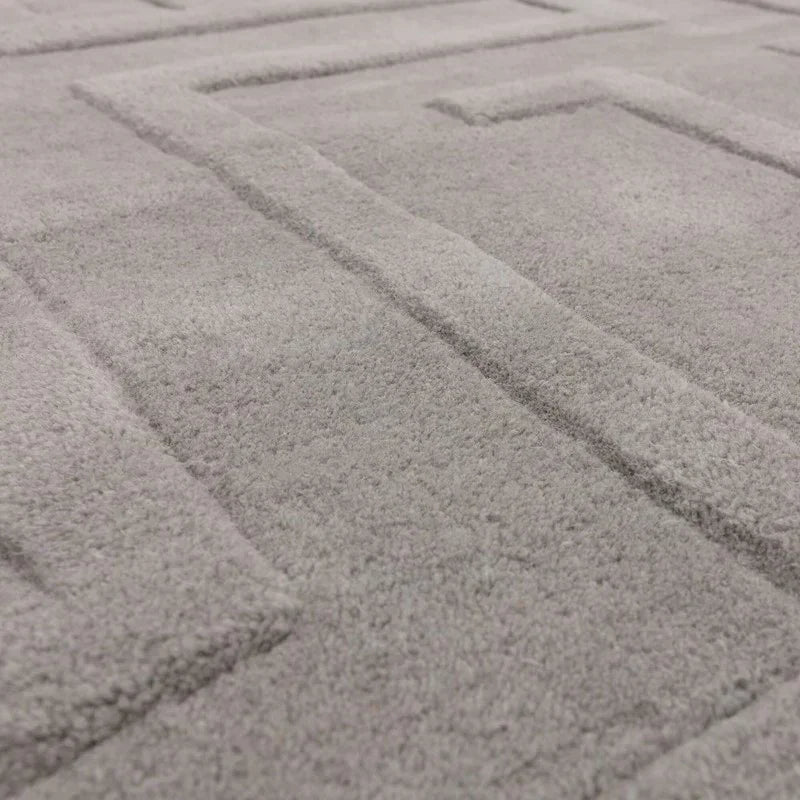 Close view of grey rug with raised geometric pattern and soft textured surface