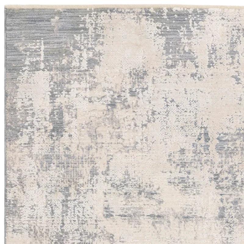 Modern abstract area rug with cream and grey pattern, close-up of soft textured surface