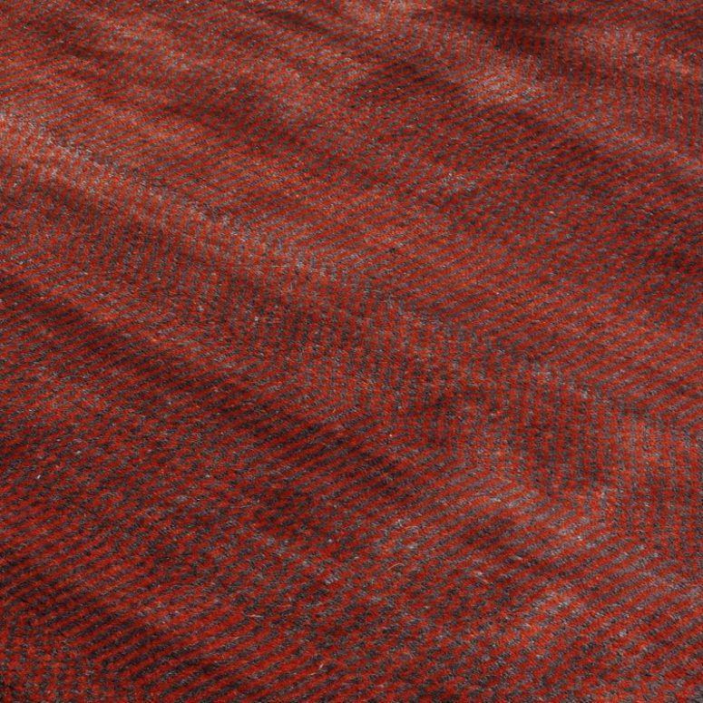 red and grey herringbone wool fabric closeup with textured pattern