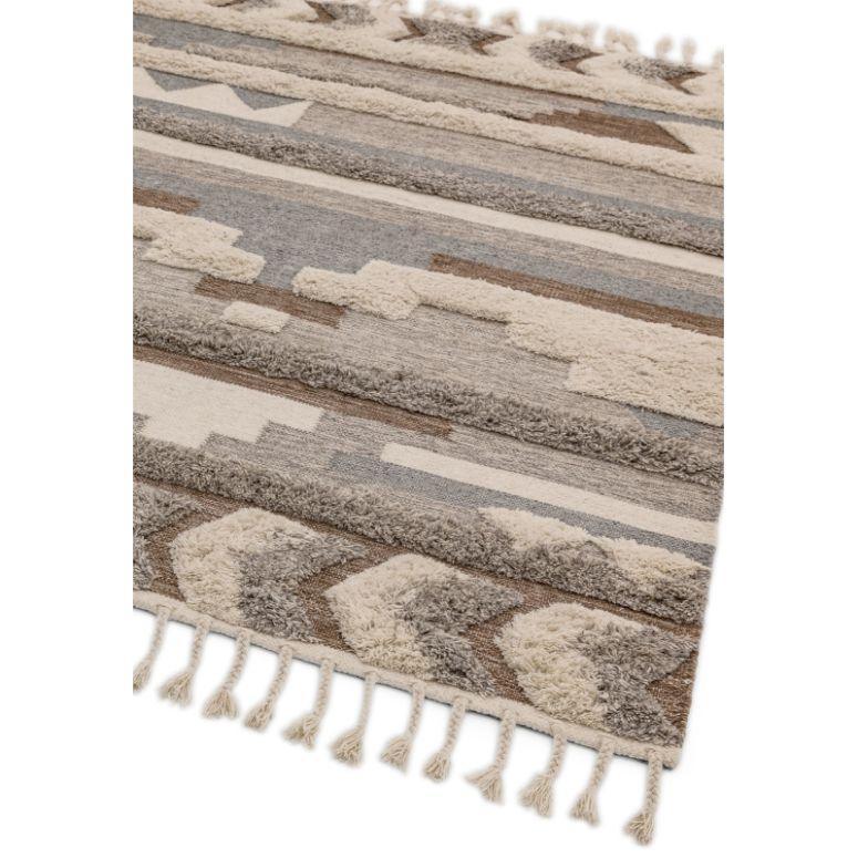 Geometric patterned rug with tassels in neutral beige, grey and brown tones