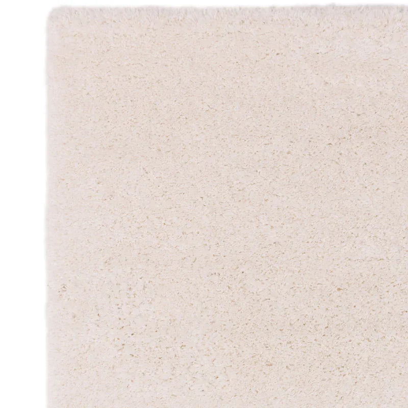 close-up of cream shaggy rug corner with soft pile texture