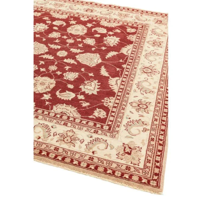 Red patterned area rug with cream floral border detail