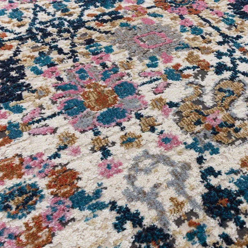 Multi-coloured patterned rug with cream base, blue, pink and rust geometric floral accents