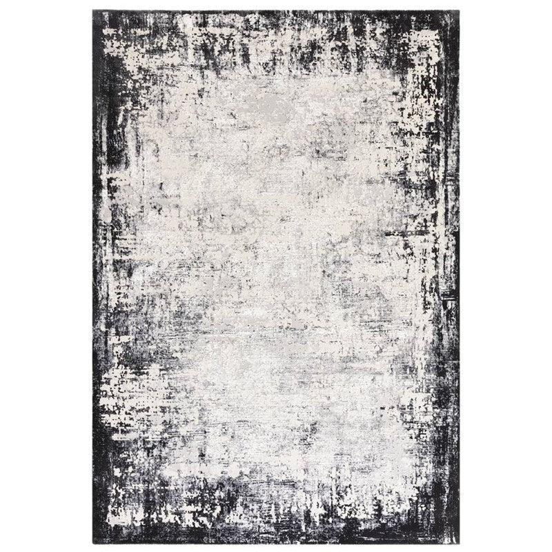 Modern area rug with distressed black and grey border on a light background