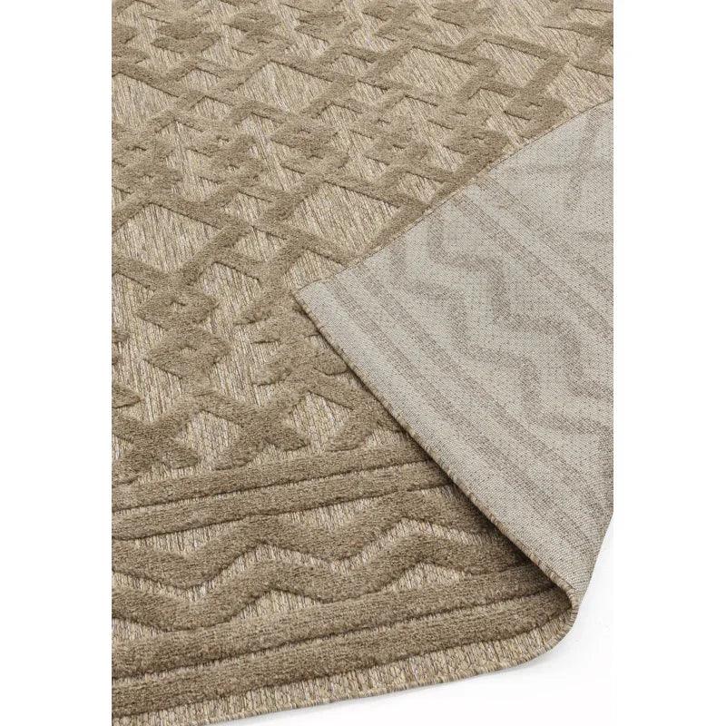 Beige geometric patterned area rug with textured pile and corner lifted to show backing