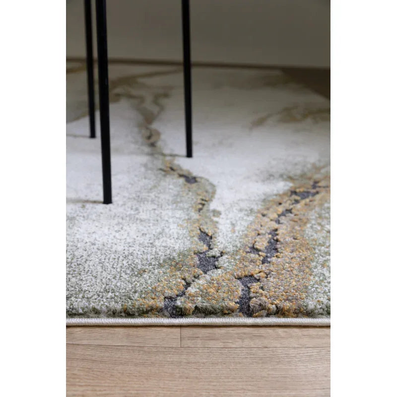 Modern abstract pattern rug with earthy tones beside a wooden floor and black table legs