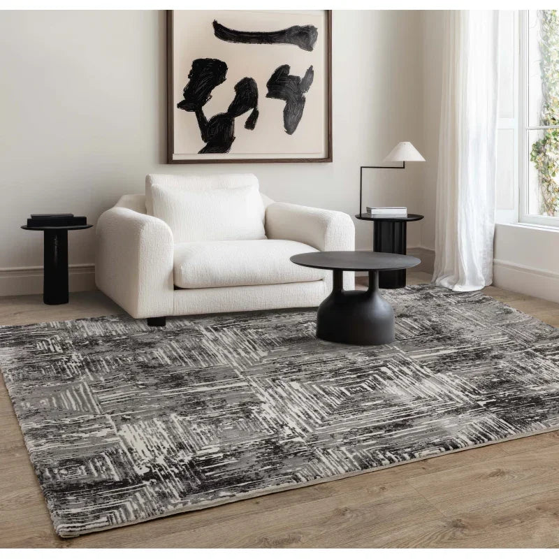 Modern grey patterned rug in living room with white armchair and black coffee table