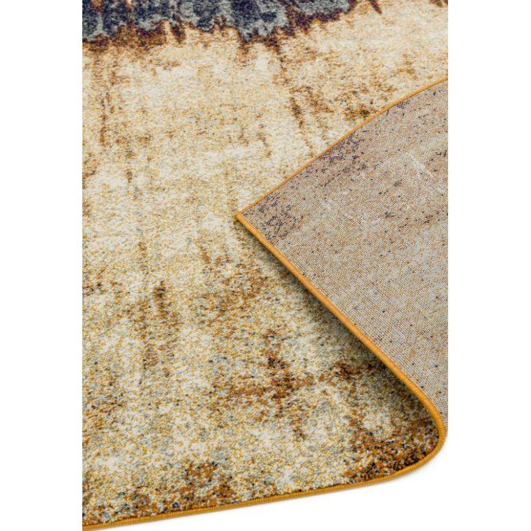 Beige patterned area rug corner flipped to show underside texture and binding