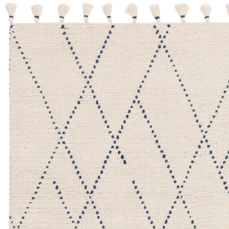 Cream woven rug with navy diamond pattern and tassel edge detail