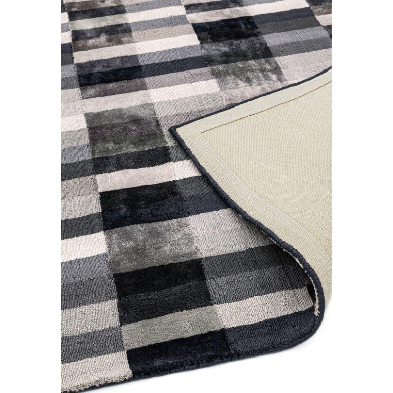 Grey checked rug with plush texture and corner flipped to show backing