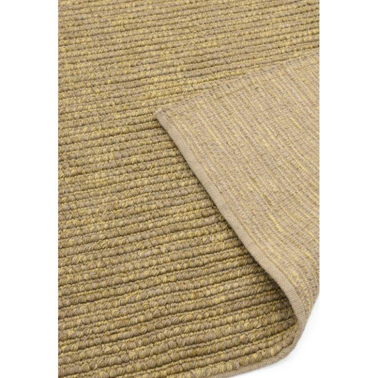 Beige woven rug with textured surface and corner folded over