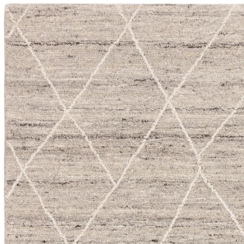 Beige wool rug with diamond pattern and textured pile, close-up corner view