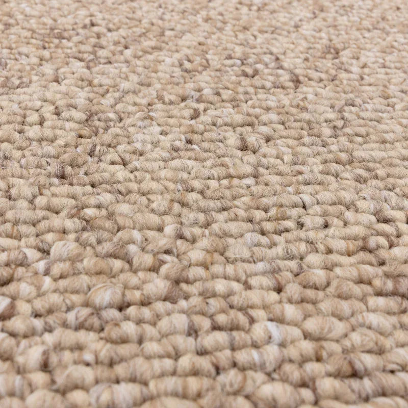Close-up of beige wool loop pile carpet texture for living room or bedroom flooring