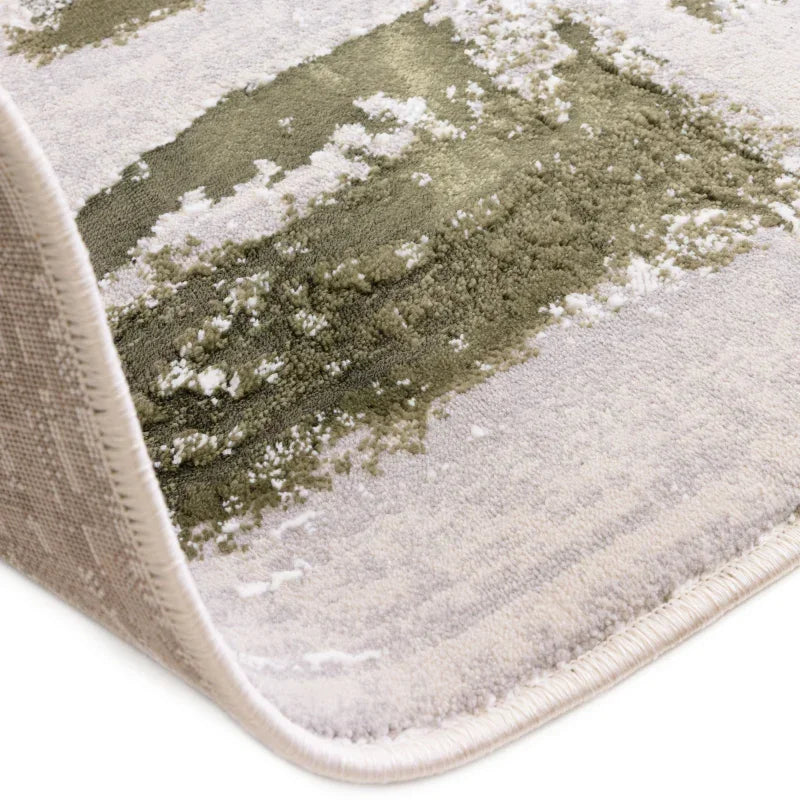 Close view of green and cream patterned area rug corner showing texture and edging
