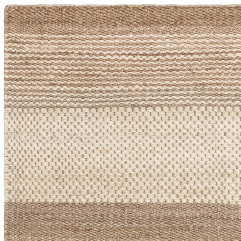 Woven wool rug with beige and cream stripes and textured surface, close-up view