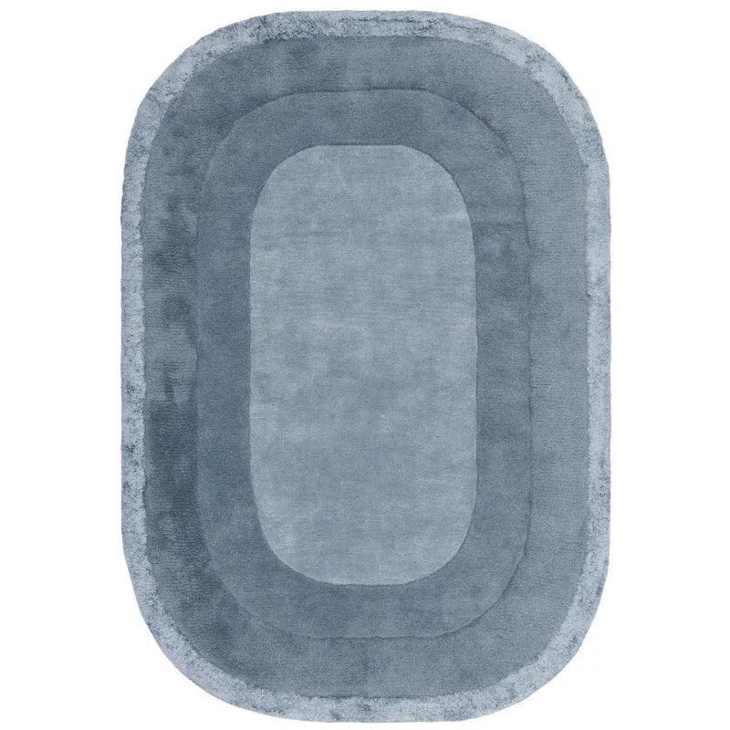 Blue oval area rug with layered border pattern and soft plush texture