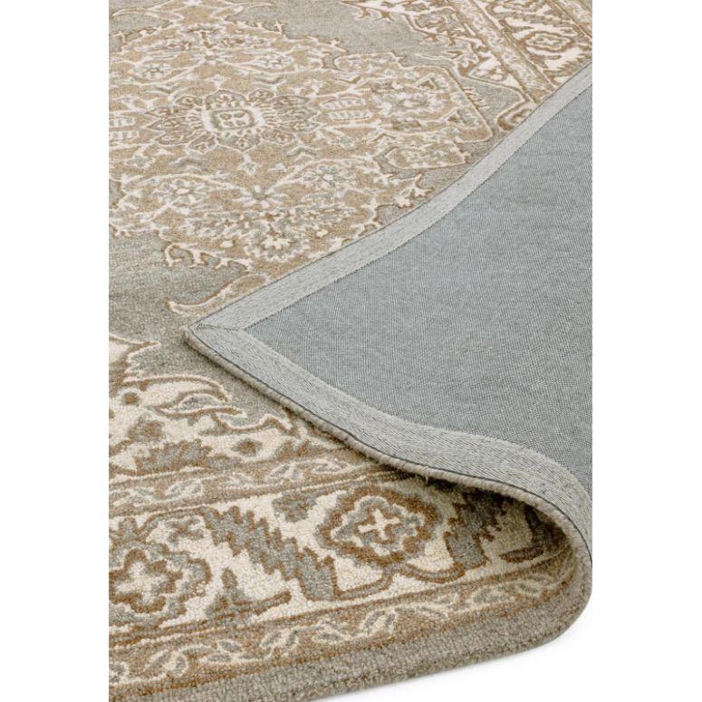 Beige patterned area rug with traditional design and corner folded to show backing