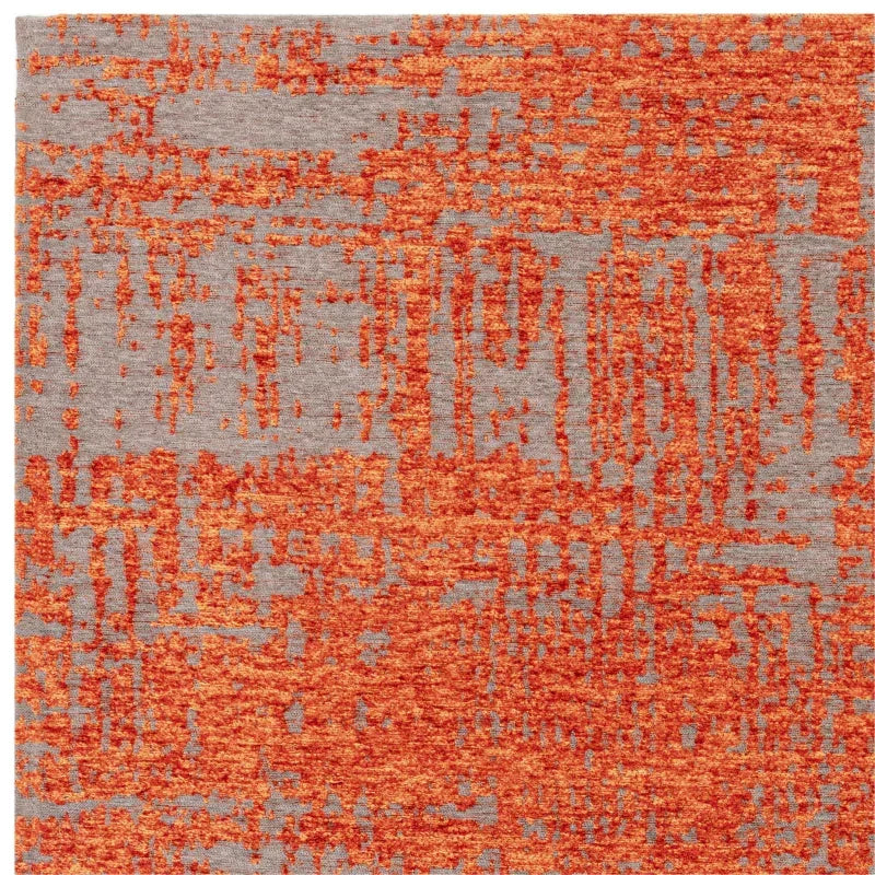 Contemporary area rug with orange abstract pattern on a grey background