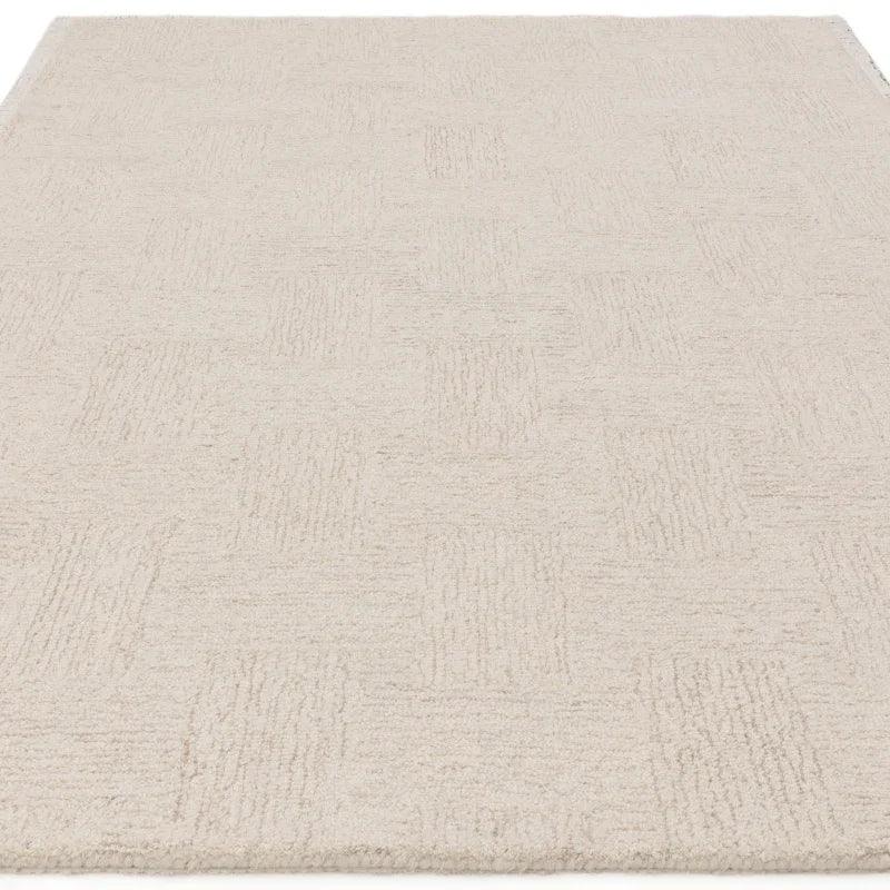 Cream textured area rug with subtle geometric pattern, shown from an angled top view
