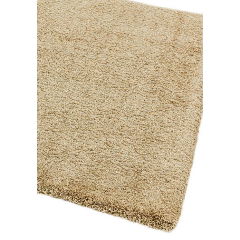 Beige area rug corner with soft textured pile and plain design