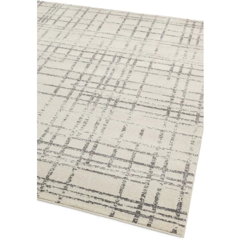 Cream area rug with modern grey geometric grid pattern, shown from corner angle