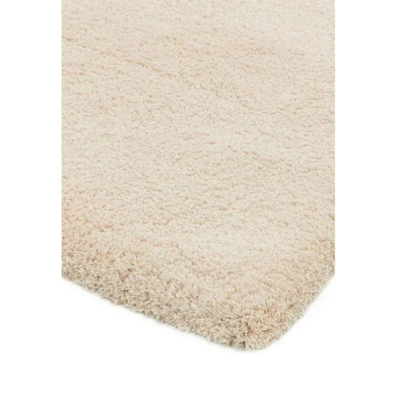 Closeup of cream shaggy rug corner showing thick, soft pile texture
