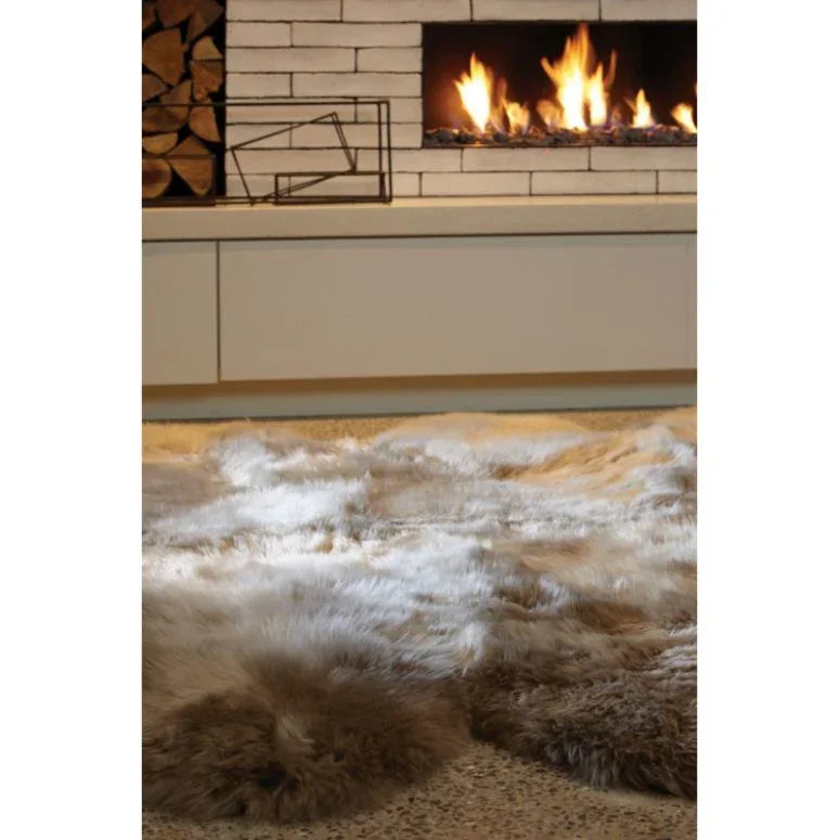 Beige sheepskin rug on living room floor with modern fireplace in background