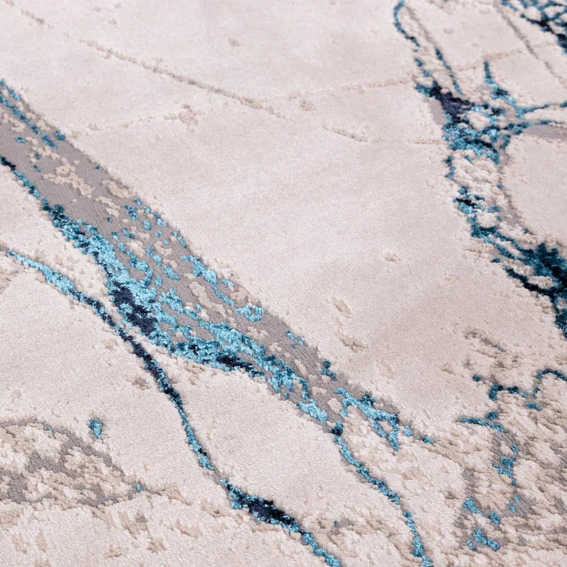 Modern abstract area rug with cream, grey, and blue pattern close-up