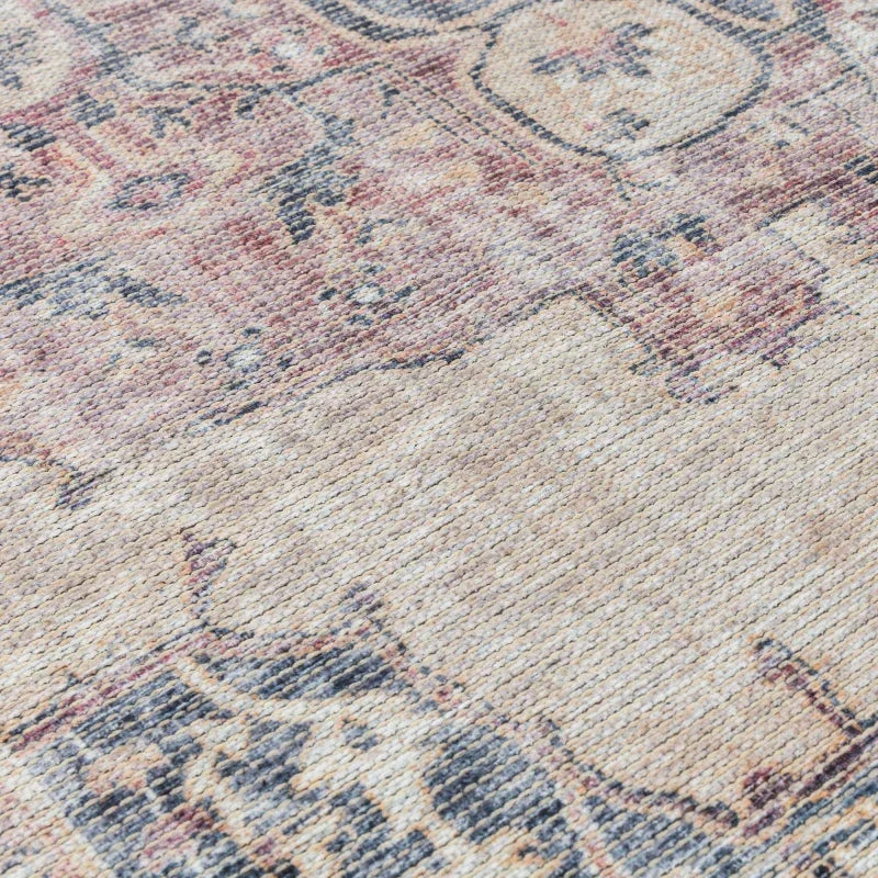 Close up of woven rug with faded beige, blue and pink vintage pattern