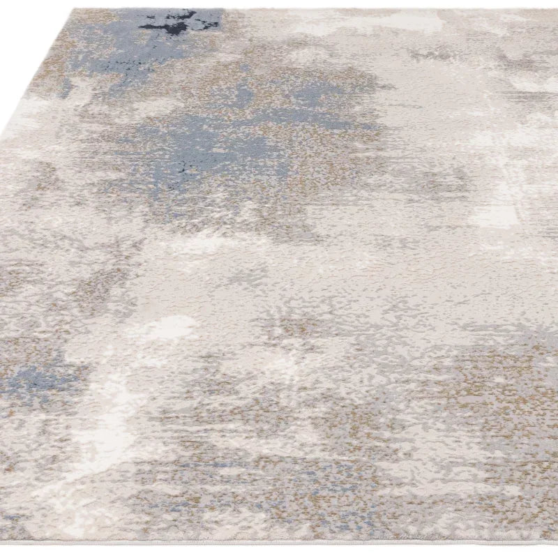 Abstract area rug with grey, beige, and blue pattern on textured surface