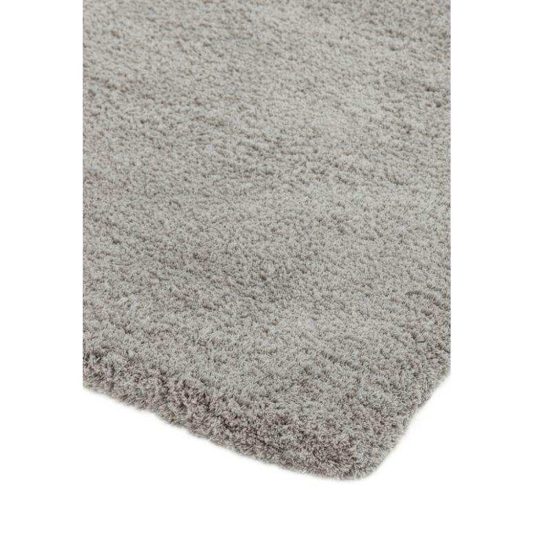 Close-up of light grey shaggy rug corner showing plush texture and pile