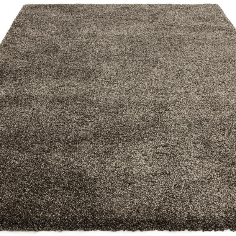 Dark grey shaggy rug with thick pile on white background, front angle view