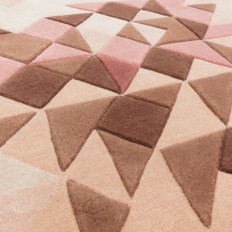 Geometric patterned rug in pink and brown tones with textured triangular shapes