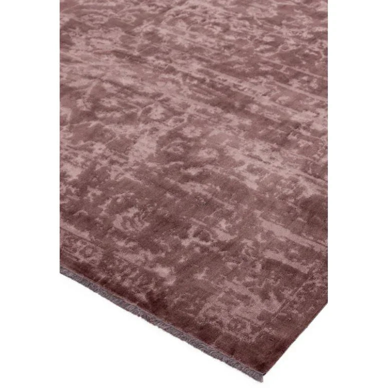 Mauve area rug with textured pattern and soft plush finish, corner view