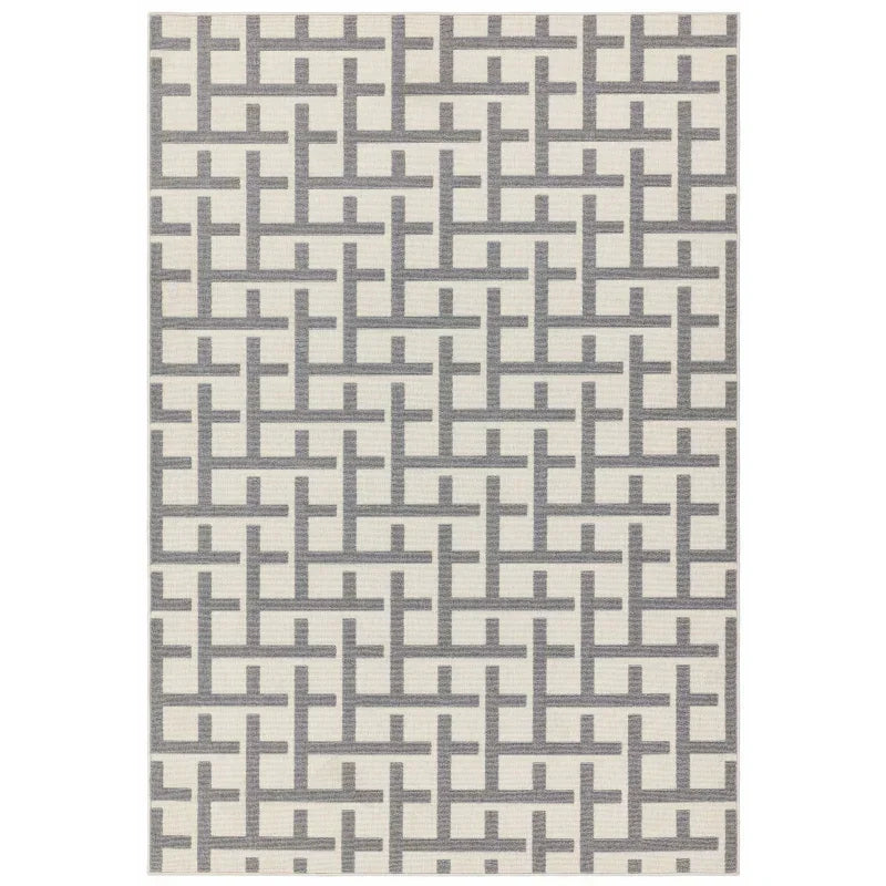 Grey geometric pattern area rug on cream background