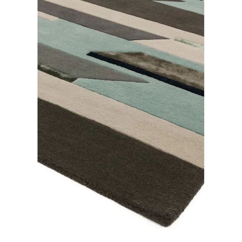 Geometric wool rug with blue, grey, and beige stripes, close-up of corner detail