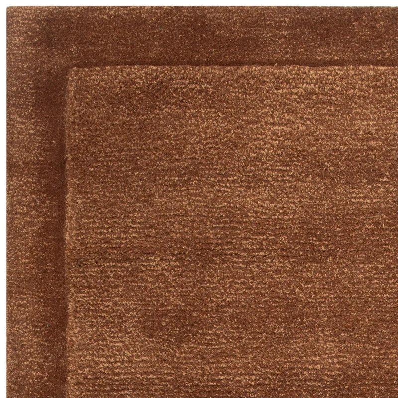 Brown textured area rug with solid border and soft pile, corner angle view