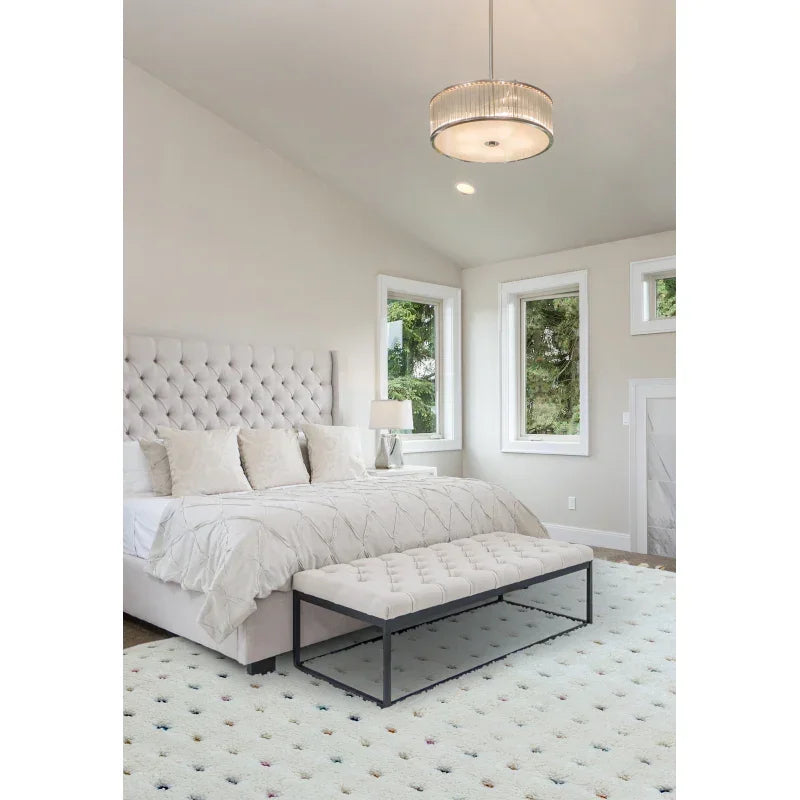 Tufted upholstered bed with white bedding, matching bench, and modern bedroom furniture