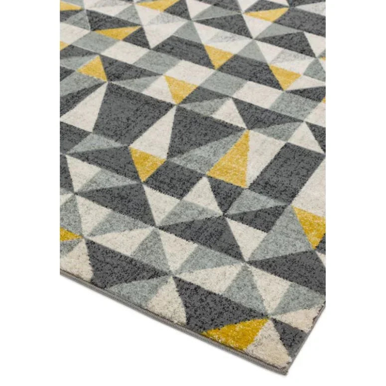Geometric area rug with grey, yellow, and white triangles on soft textured surface
