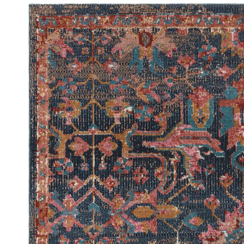Traditional patterned area rug with blue, rust and gold colors, close-up corner view