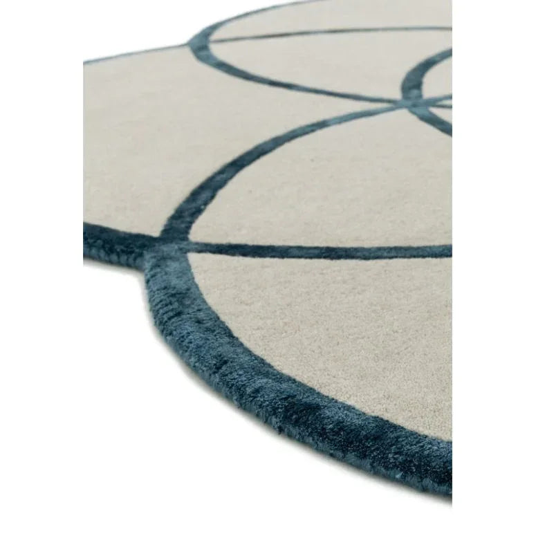 Cream and blue geometric round rug with raised border detail, close angle view