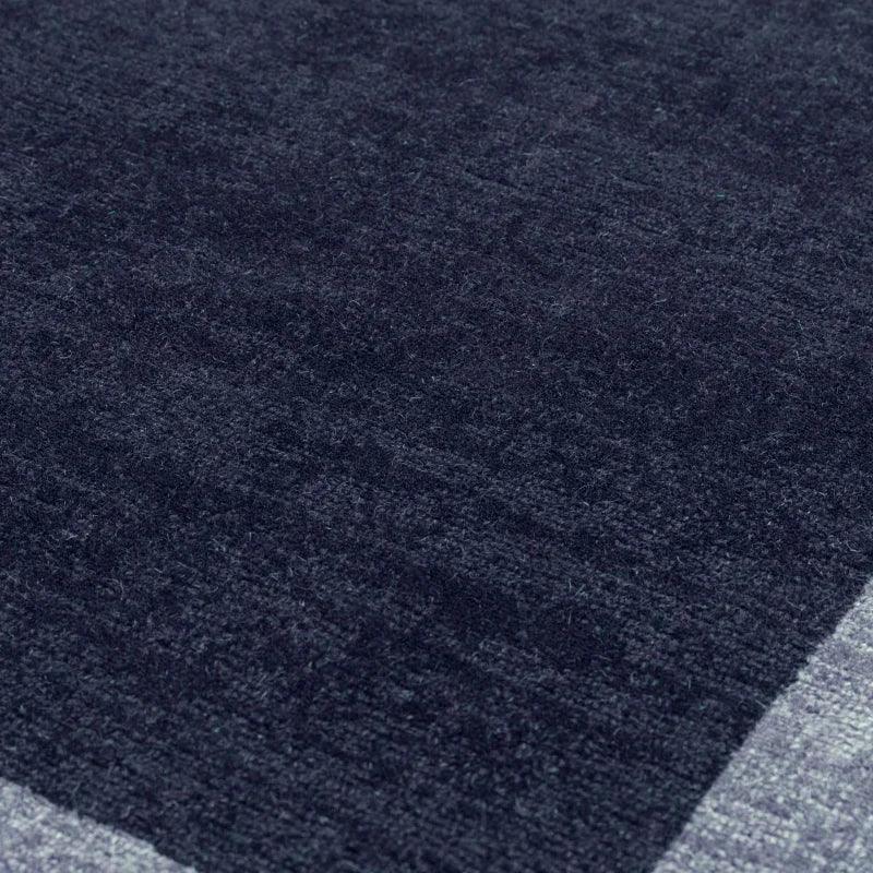 Close-up of dark grey textured rug with subtle corner detail