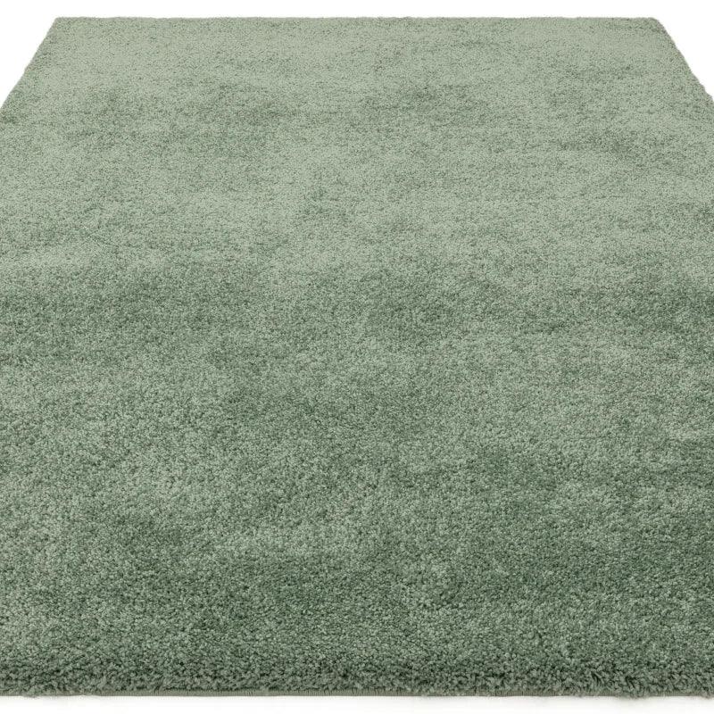 Green shaggy rug with soft textured pile, shown from a low angle