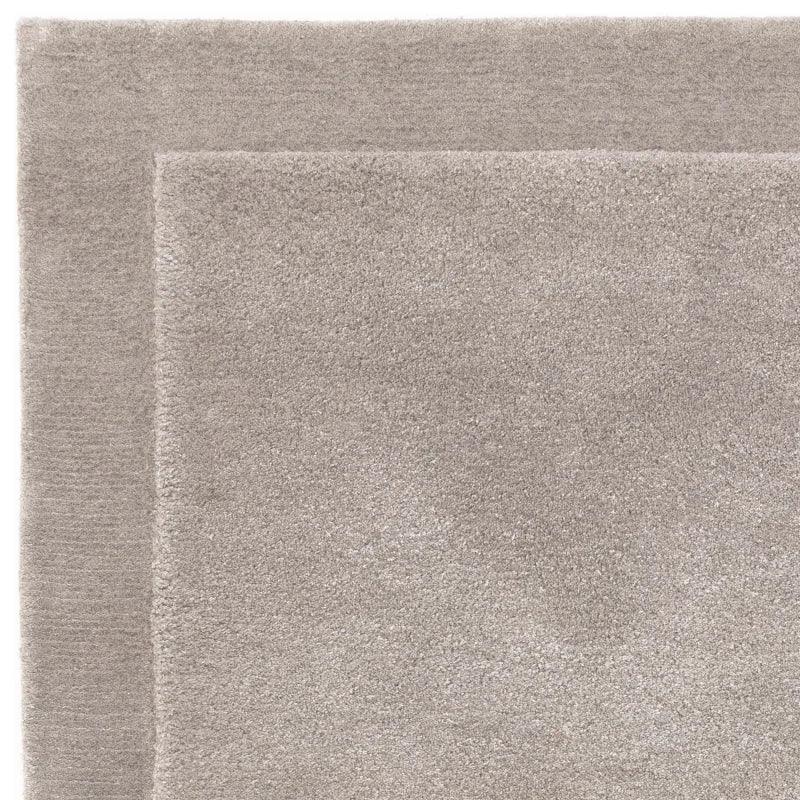 Closeup of beige area rug with soft plush texture and simple border design