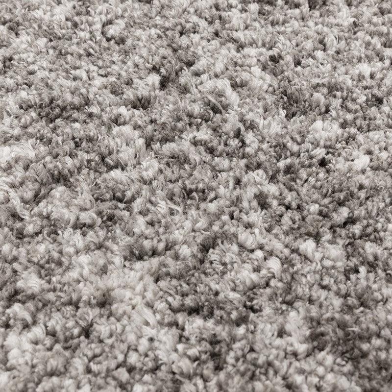 Close-up of grey and white shaggy rug texture with soft, thick pile
