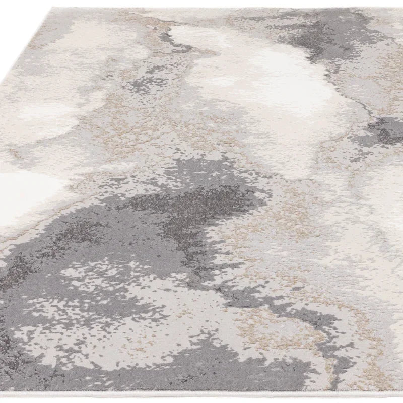 Abstract area rug with grey, beige, and cream pattern on textured surface