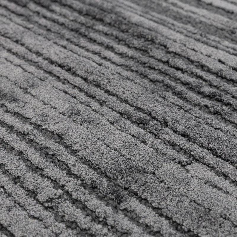 Closeup of grey textured rug with raised striped detail