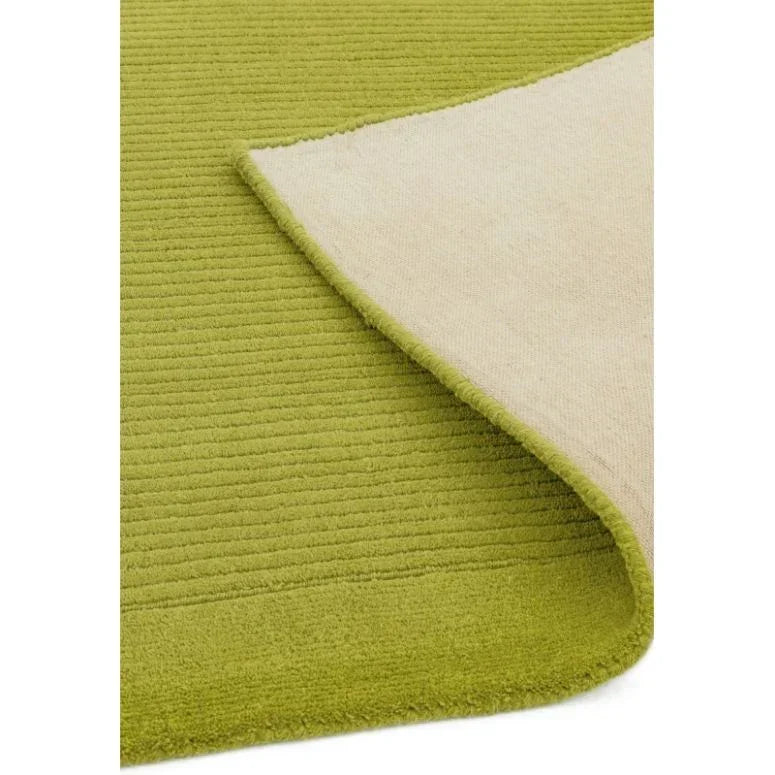 Green textured area rug with visible ribbed pattern and turned-up corner showing backing
