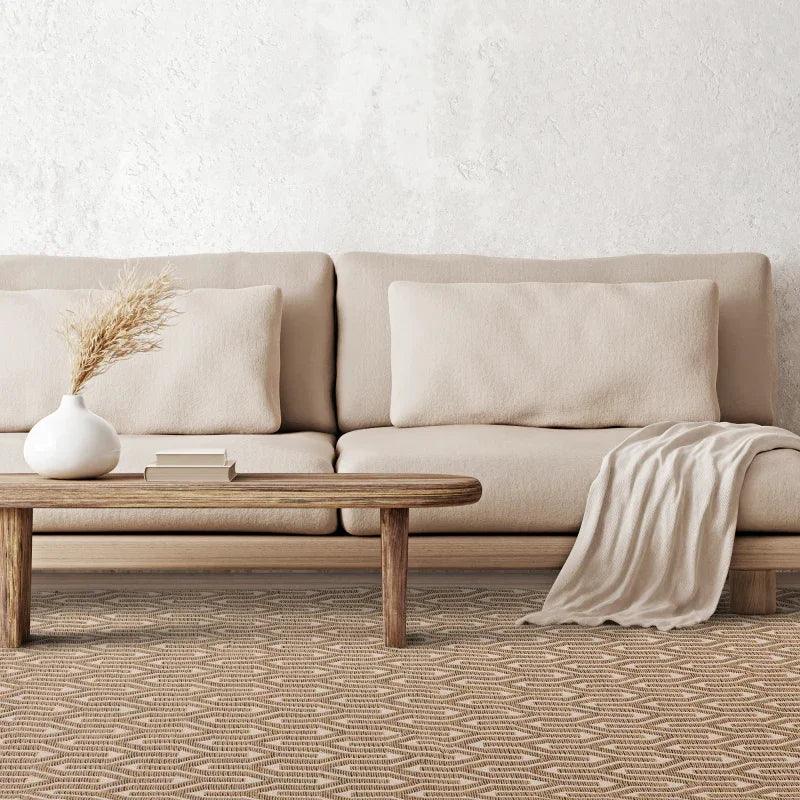 Beige fabric sofa with wooden coffee table and cream throw in modern living room setting